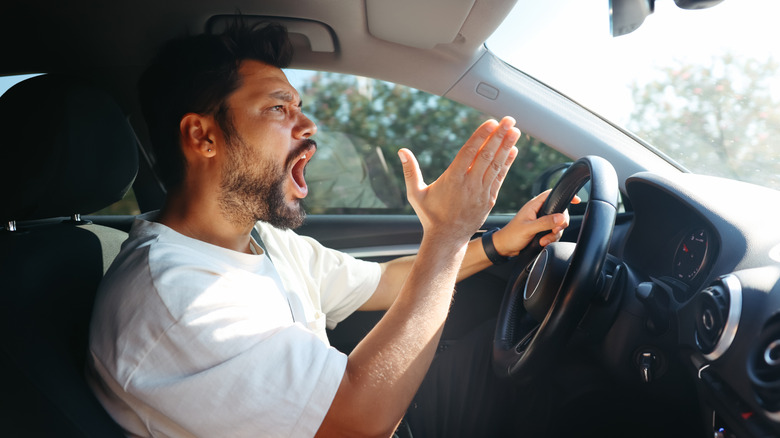 An angry man driving a car