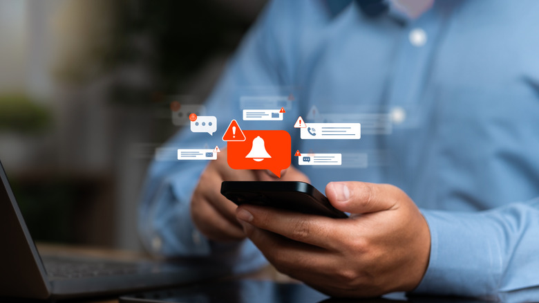 A man holding a cell phone with graphics of warning images