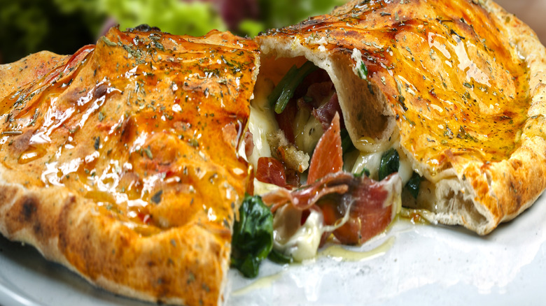 Close-up on a calzone style stuffed pizza