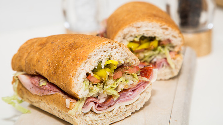 Submarine sandwich with Italian meats and vegetables on a white counter