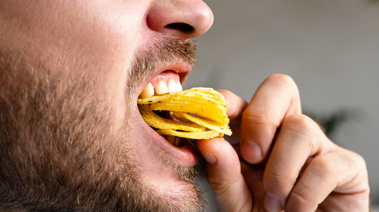 Closeup of man eating chips,