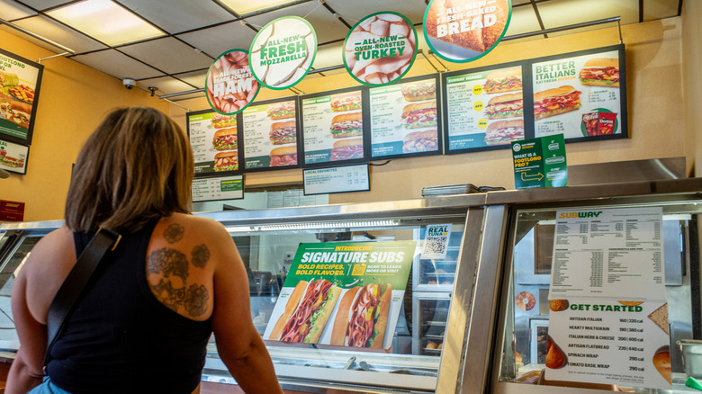 A customer waits to order food at a Subway fast-food restaurant