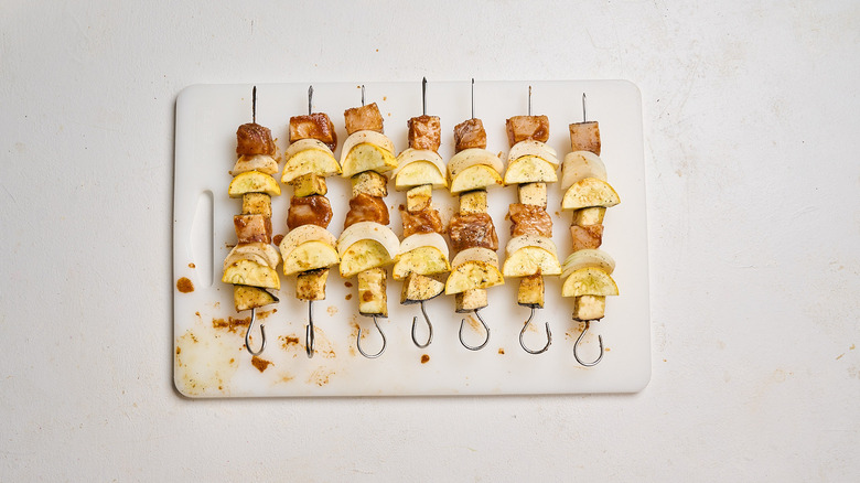 arranging vegetables and swordfish onto skewers