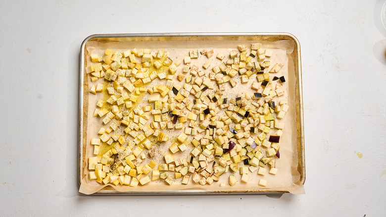 vegetables on a sheet tray with oil and seasoning