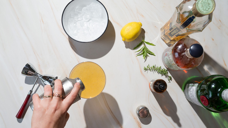 Pouring cocktail from a shaker to coupe glass
