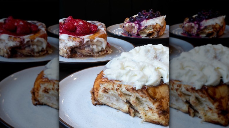 assortment of cinnamon rolls, including one topped with raspberries and one topped with blueberries
