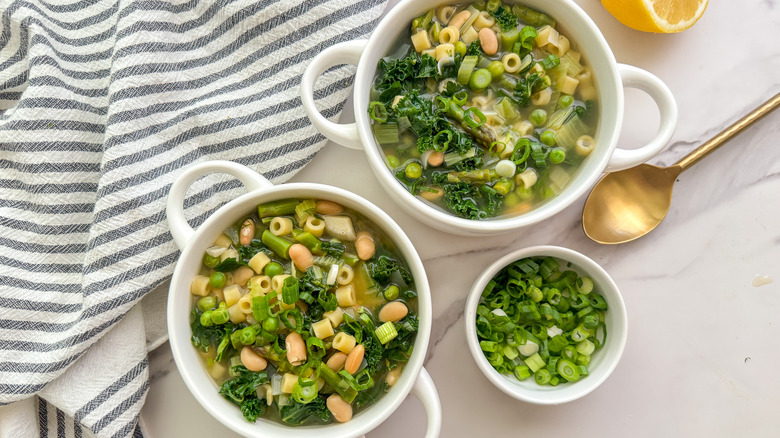 2 bowls of soup with bowl of green onions