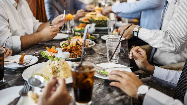 diners at restaurant with table filled with food and drinks
