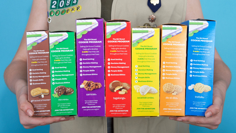 Hands holding boxes of Girl Scout cookies