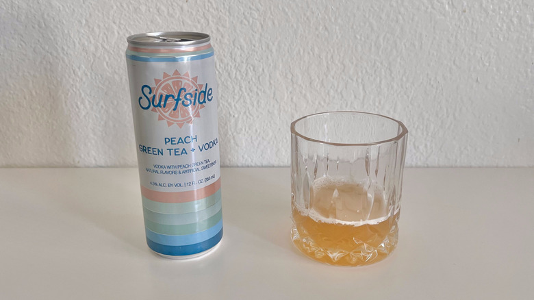 Peach Green Tea + Vodka can with a glass next to it