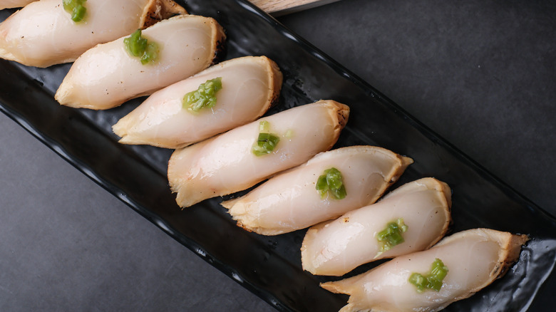 Slices of white escolar fish on sashimi plate.