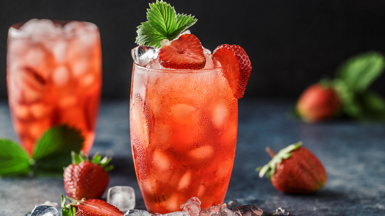 Strawberry mocktails next to whole strawberries and ice cubes