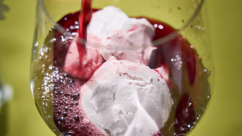 Red wine poured over vanilla ice cream in a glass.
