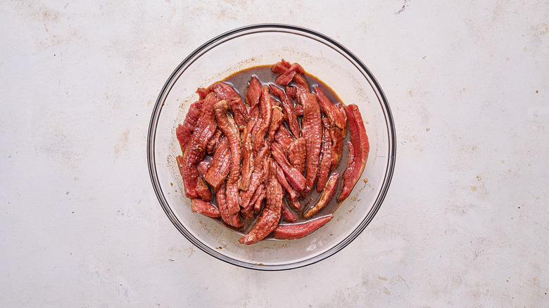 beef covered in marinade in a bowl