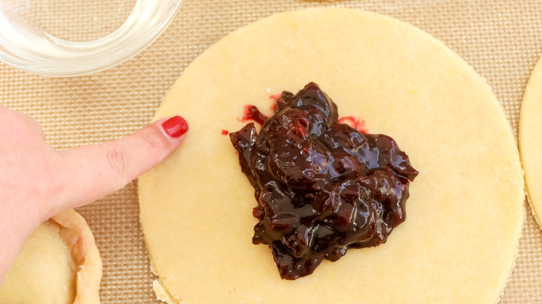 empanada dough edges being moistened with water