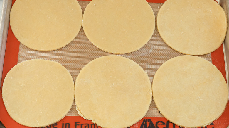 empanada dough circles on a baking sheet