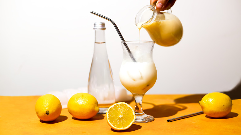 pouring creamy lemonade into glass 