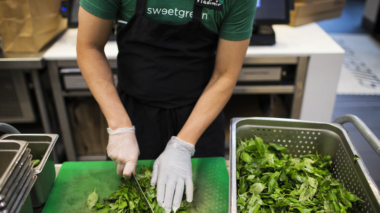 Sweetgreen employee cuts basil