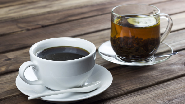 View of cup of coffee and cup of black tea with lemon on a table
