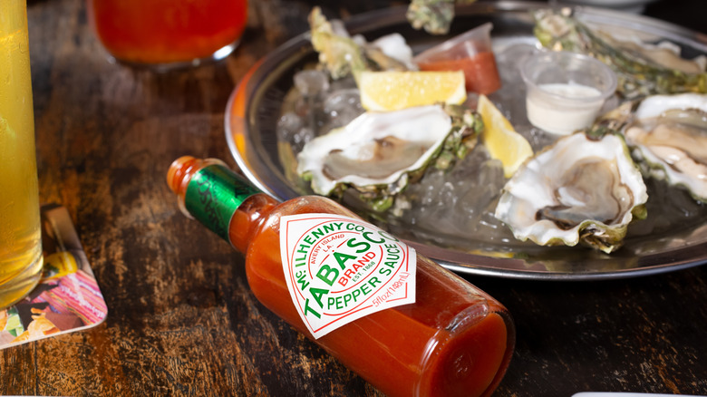 bottle of Tabasco Brand Sauce on table with oysters