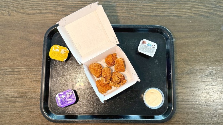 Taco Bell Diablo Dusted Crispy Chicken Nuggets in a container on a tray with sauces