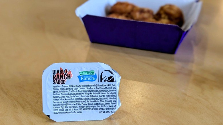A sealed container of Hidden Valley Diablo Ranch with a box of nuggets in the background