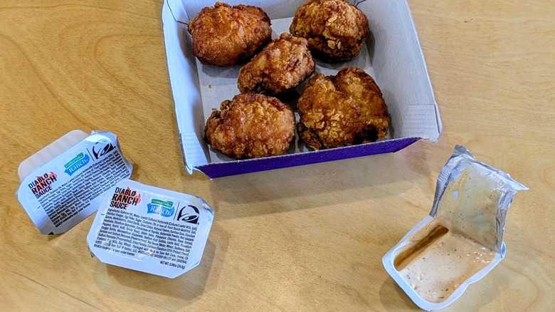 Two sealed packets and one open packet of Hidden Valley Diablo Ranch with chicken nuggets in a box