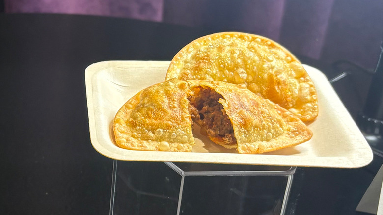 Two Mexican Pizza empanadas, one cut down the middle to reveal the inside