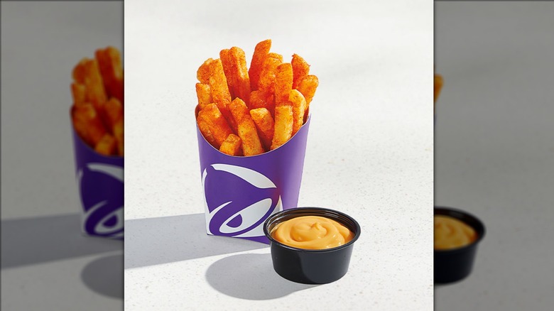 Taco Bell nachos fries with dipping sauce on beige background