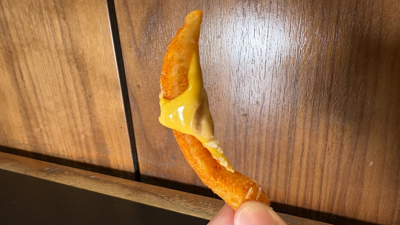 A nacho fry with cheese clinging to it