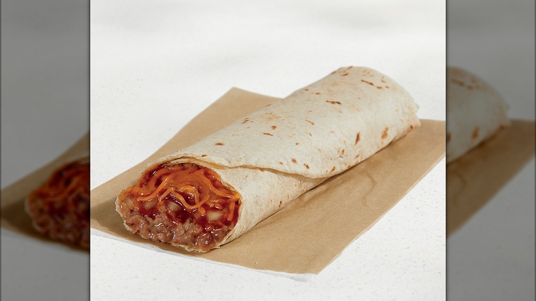 Bean burrito with cheese on a paper wrapper