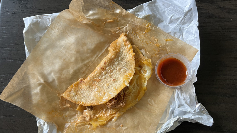 Shredded beef dipping taco with red sauce