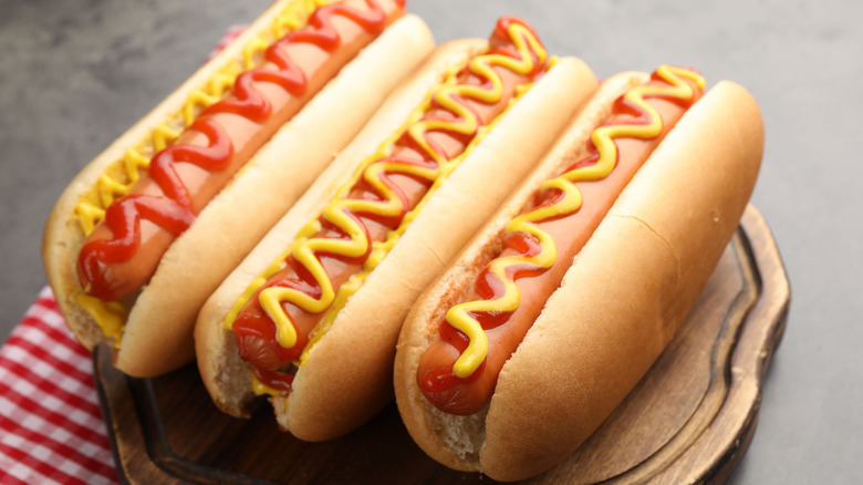 Three hot dogs with ketchup and mustard