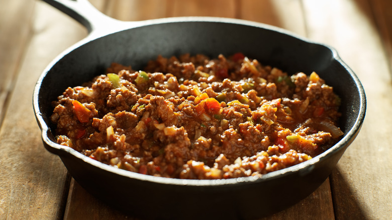 Sloppy Joe meat in a skillet on wooden table
