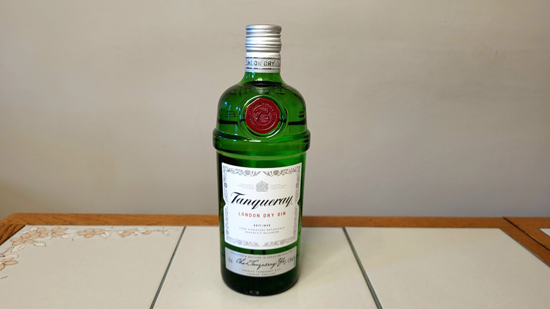 A bottle of Tanqueray on a white tile table.