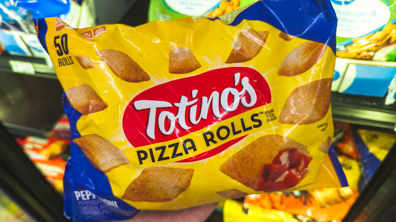 Hand holding Totino's Pizza Rolls in the frozen food aisle