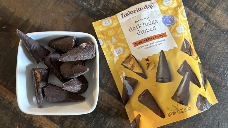 Favorite Day dark fudge dipped witch hat in bag and bowl on wooden table.