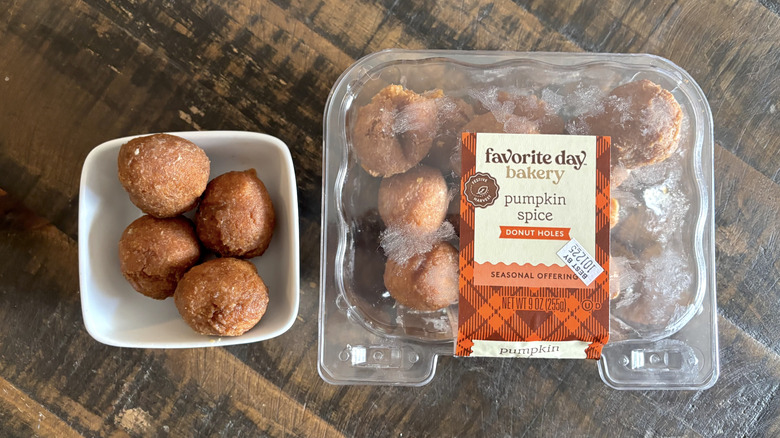 Favorite Day pumpkin spice donut holes in a package and bowl on a wooden table.
