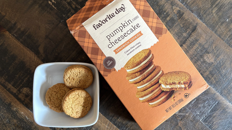 Favorite Day pumpkin cheesecake sandwich cookies in box and bowl on wooden table.