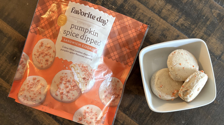 Favorite Day pumpkin spice dipped sandwich cookies in bag and bowl on wooden table.