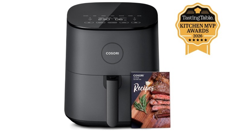 Cosori 9-in-1 Air Fryer Pro with recipe booklet against white background.