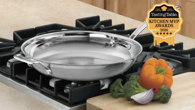 A Cuisinart MultiClad Pro Triple Ply 12-Inch Stainless Steel Skillet on a kitchen range next to a bell pepper and broccoli