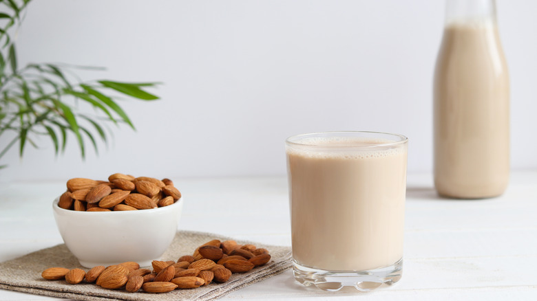 Glass of almond milk next to almonds