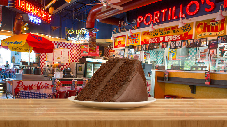 Slice of Portillo's chocolate cake on a white plate on a restaurant table