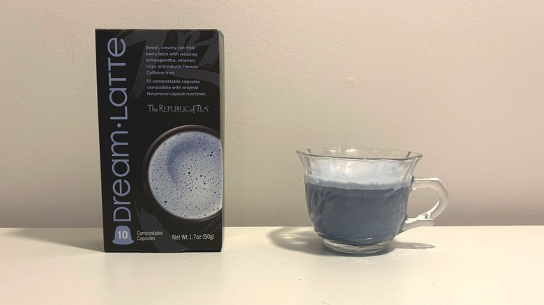 Box of Republic of Tea Dream Latte capsules next to clear cup of brewed tea on white background