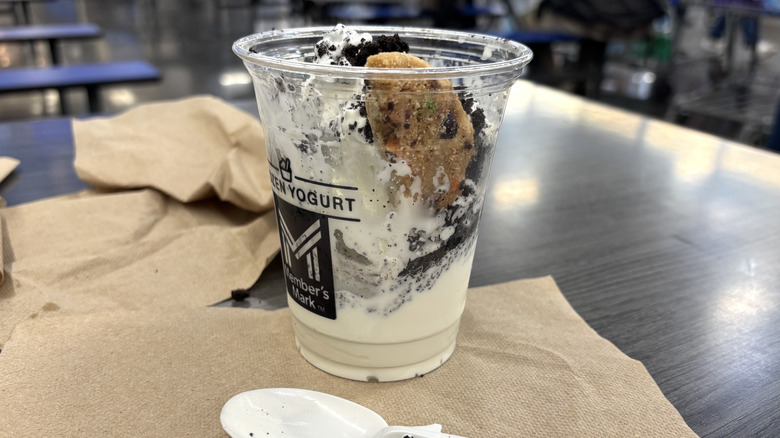 Sam's Club holiday Jingle Cookie Crunch Sundae in plastic cup on cafe table.