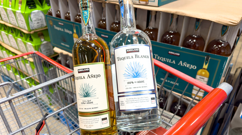 Two bottles of Kirkland Tequila Blanco and Anejo in a Costco shopping cart