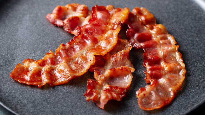 crispy bacon strips on black plate
