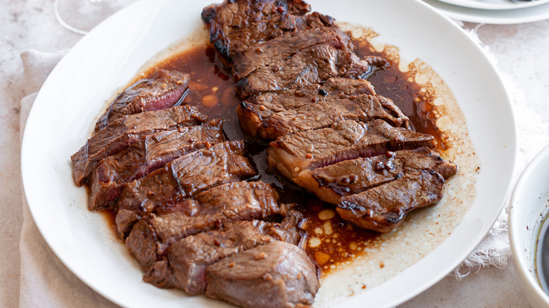 sliced steak with marinade bowl