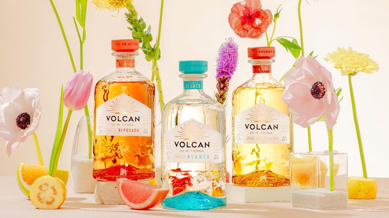 Three bottles of Volcan surrounded by flowers
